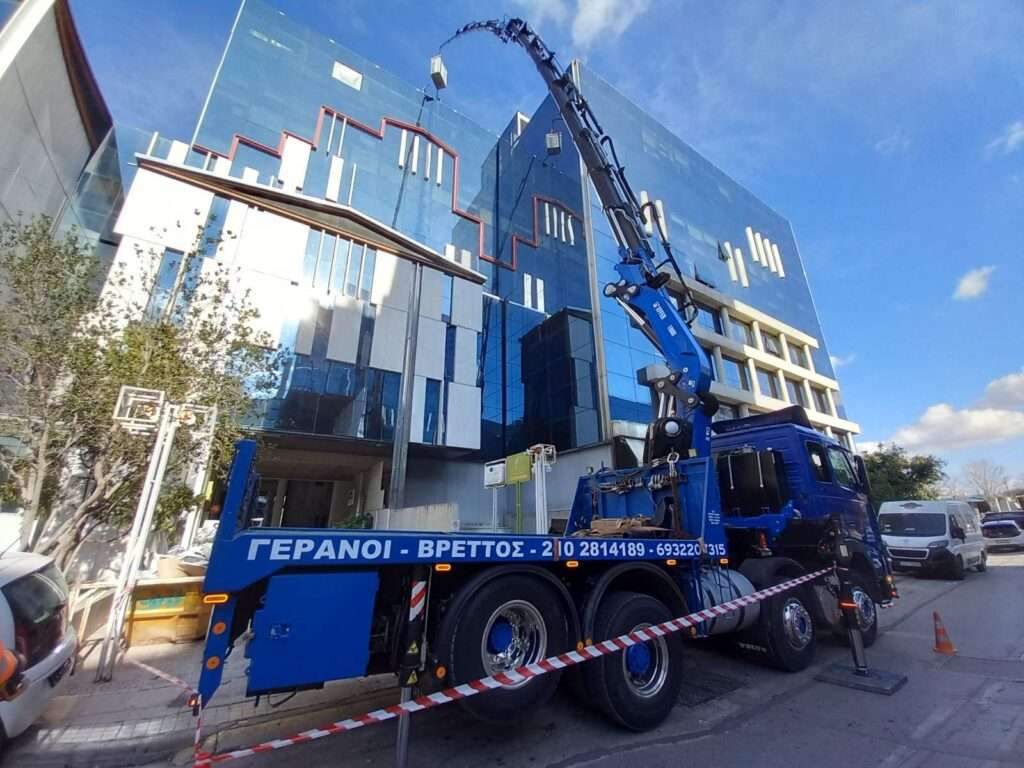 Γερανοφόρο όχημα σε ανύψωση υλικών σε πολυώροφο κτίριο με καθρέπτες - Βρεττός Γερανοί