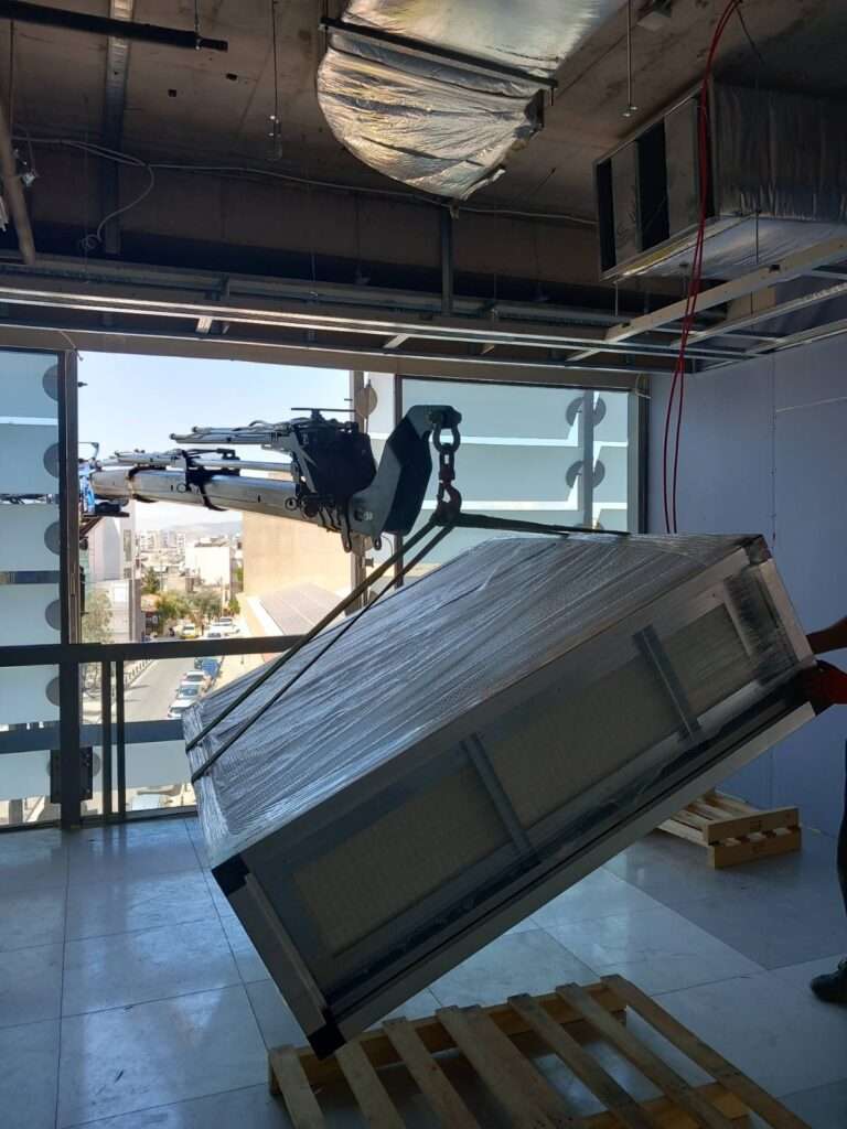 Γερανοφόρο όχημα σε τοποθέτηση κλιματιστικής μονάδας σε όροφο κτιρίου μέσω παραθύρου - Βρεττός Γερανοί