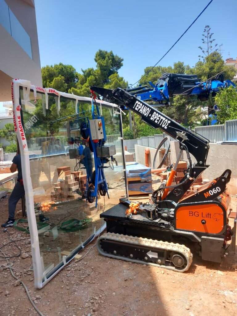 Mini ερπυστριοφόρος γερανός BG Lift M060 σε συνεργασία με γερανοφόρο όχημα για τοποθέτηση υαλοπίνακα - Βρεττός Γερανοί
