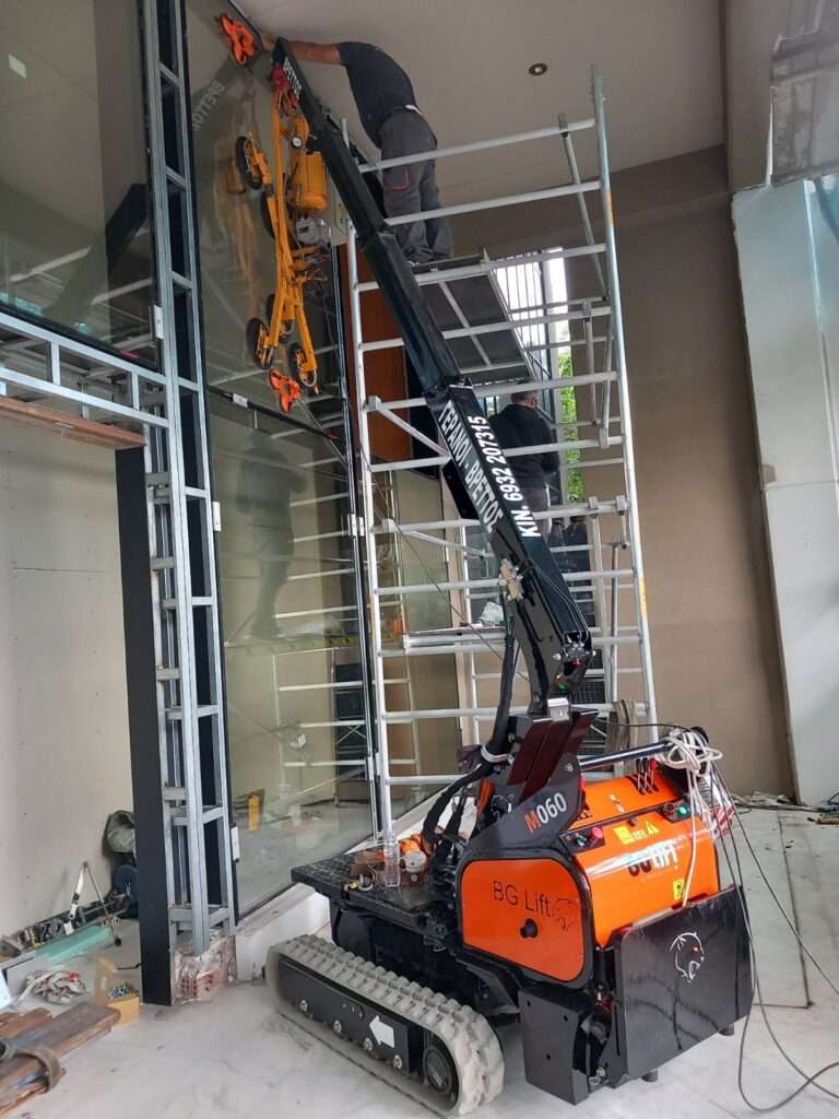 Mini ερπυστριοφόρος γερανός BG Lift M060 σε τοποθέτηση τζαμιού σε εσωτερικό κτιρίου με μεγάλο ύψος - Βρεττός Γερανοί