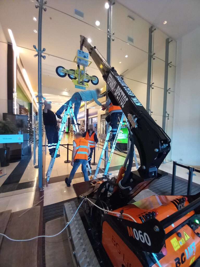 Τοποθέτηση τζαμιών σε εμπορικό κέντρο με mini ερπυστριοφόρο γερανό BG Lift - Βρεττός Γερανοί