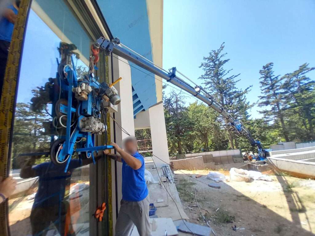 Τοποθέτηση τζαμιού σε εξωτερικό χώρο με γερανό παπαγάλο και βεντούζα - Βρεττός Γερανοί