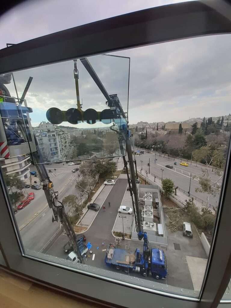 Τοποθέτηση τζαμιών σε κτίριο με γερανό και ειδική βεντούζα ανύψωσης υαλοπινάκων - Βρεττός Γερανοί Αθήνα
